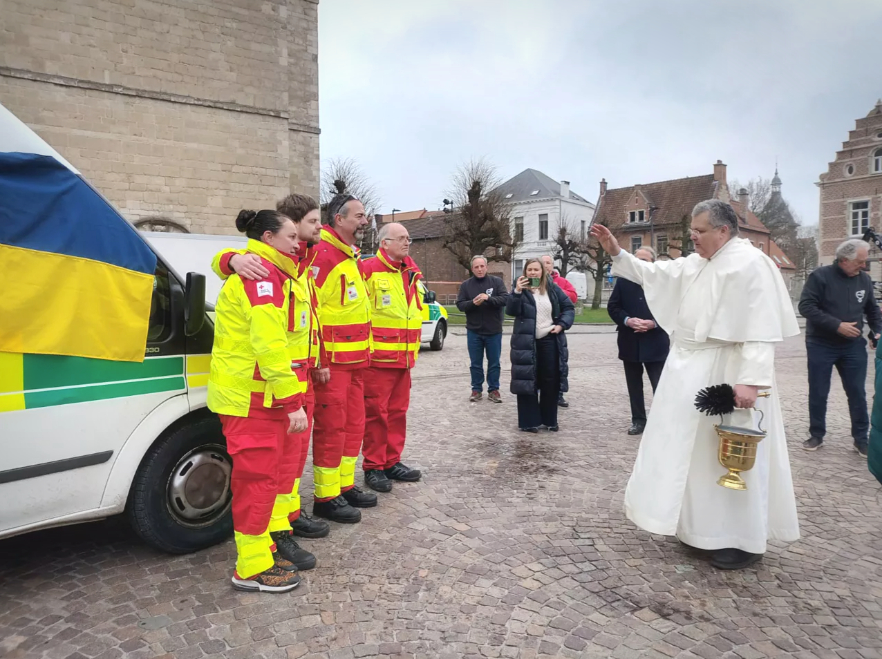 Pater Karel zegent aan de abdij van Grimbergen de ambulanciers en de ziekenwagen.