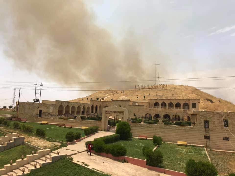 De rook komt van de graanvelden rond Karemlesh die in brand ziujn gestoken